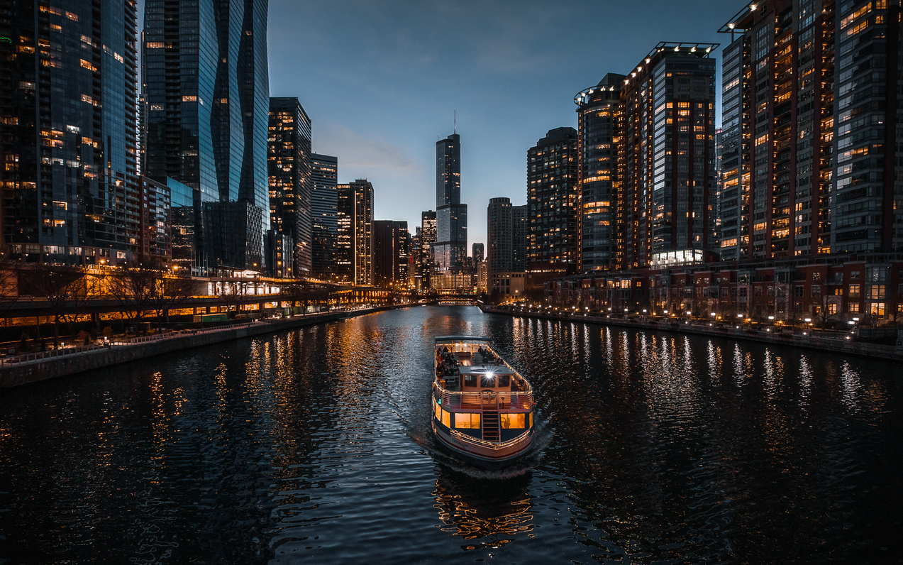 Boat on Water Near City Buildings at Night